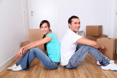 Movers carrying furniture through a London apartment building staircase